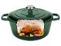 Cocotte verte avec un poulet rôti et des légumes à l'intérieur.