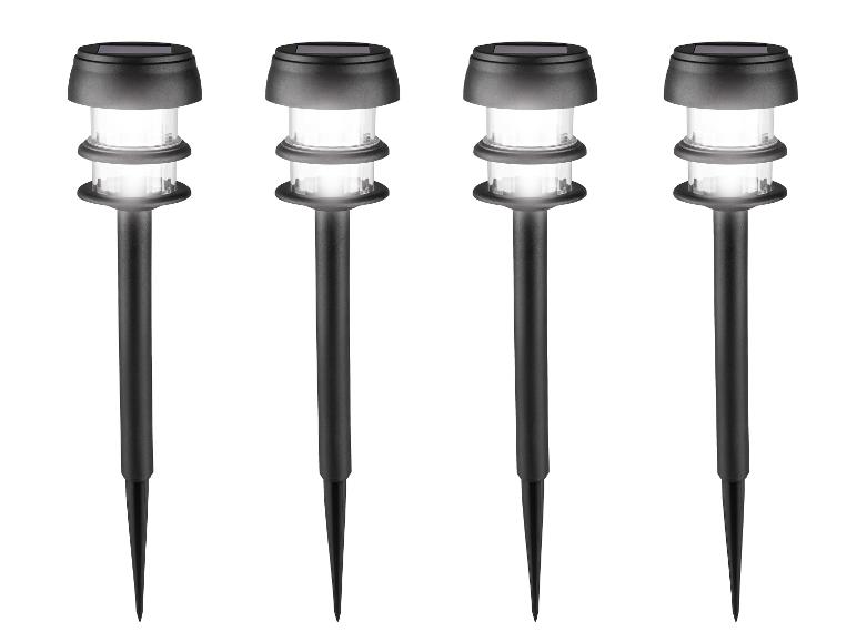 Quatre lampes solaires de jardin noires avec des lumières blanches brillantes