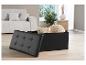 Une boîte de rangement noire à boutons, ouverte avec des coussins à l'intérieur