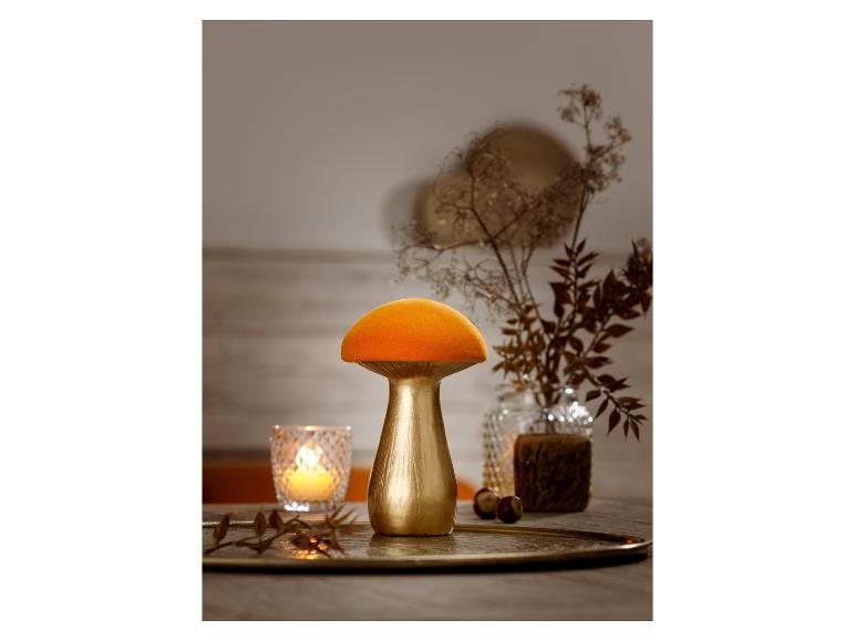 Lampe dorée en forme de champignon avec un abat-jour orange.