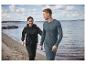 Un homme et une femme en sweat-shirts noirs et pantalons de survêtement sur la plage.