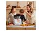 Une famille cuisine ensemble dans la cuisine en utilisant un Thermomix.