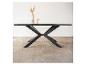 Table en bois noir avec piètement métallique en X, décorée d'un vase et d'une bougie.