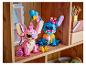 Deux figurines Lego Stitch et Angel sur une étagère en bois, avec des accessoires.