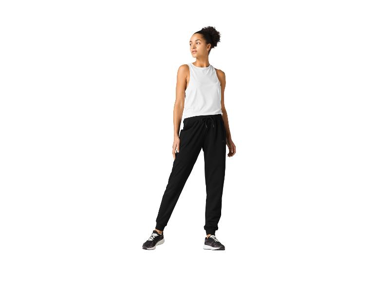 Femme portant un haut blanc et un pantalon de jogging noir.