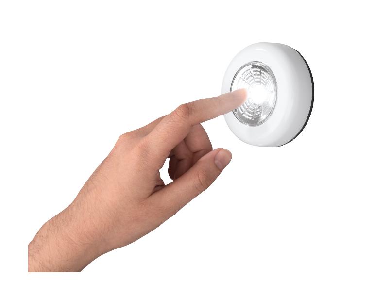 Main touchant une lampe LED tactile, l'allumant.