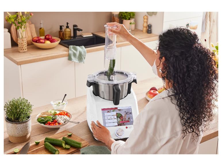 Une femme utilise un robot culinaire intelligent Monsieur Cuisine Connect pour transformer des légumes.
