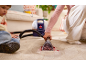 Enfant salissant et femme nettoyant un tapis avec un nettoyeur de taches.