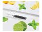 Couteau d'office, citrons, limes et menthe sur une surface blanche.