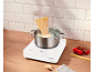 Cuisson de spaghettis dans une casserole sur une plaque à induction, avec tomates et pâtes crues.