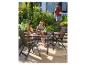 Famille profitant d'un repas en plein air sur une terrasse avec mobilier de jardin.