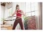 Femme faisant de l'exercice avec un hula hoop à la maison.