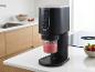 Machine à glace noire avec smoothie aux fraises dans une cuisine moderne.