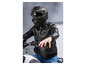 Un motard avec un casque noir et une veste en cuir sur une moto.