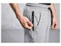 Pantalon de survêtement gris avec une poche zippée.