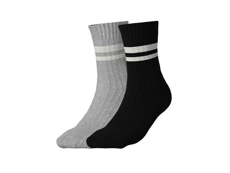 Deux paires de chaussettes pour enfants : une grise à rayures blanches, une noire à rayures blanches.