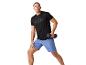 Homme faisant du sport avec haltères, t-shirt noir et short bleu.