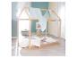 Lit cabane en bois avec literie blanche et rose, coussins étoiles et décoration de chambre d'enfant.