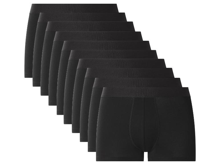 Une pile de dix boxers noirs pour hommes, soigneusement pliés et disposés en diagonale.