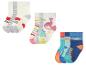 Trois ensembles de chaussettes pour enfants : un avec des cœurs, un avec des dinosaures et un avec des rayures et des dinosaures.