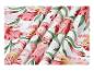 Tissu blanc à fleurs roses et feuilles vertes, disposé en plis.