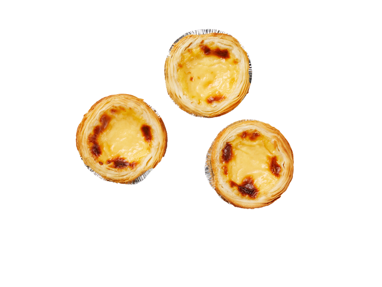 Trois tartelettes à la crème dorées sur fond noir.