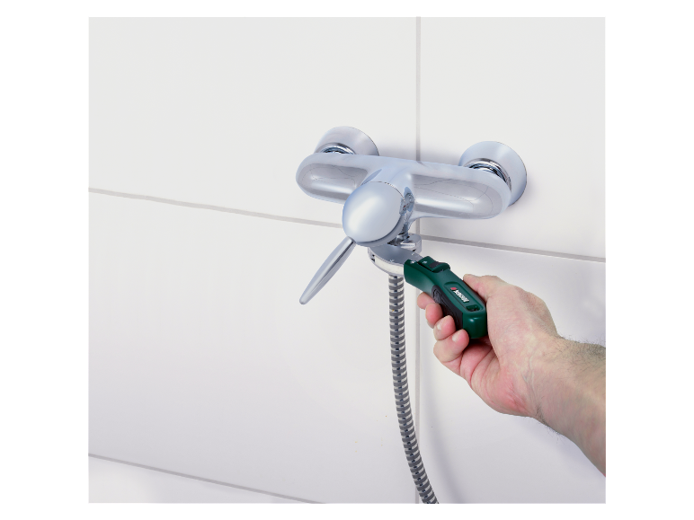 Un homme utilise une clé Parkside pour réparer un mitigeur de douche.