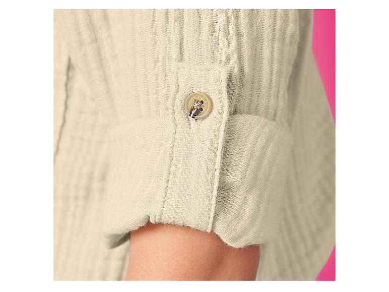 Gros plan d'une manche de chemise en lin beige avec manchette retroussée et bouton