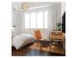 Chambre avec lit blanc, chaise marron et meuble en bois avec télévision.