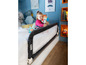 Un enfant dans un lit avec une barrière de sécurité Safety 1st.