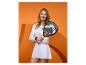 Femme en tenue de sport blanche tenant une raquette de padel sur fond orange.