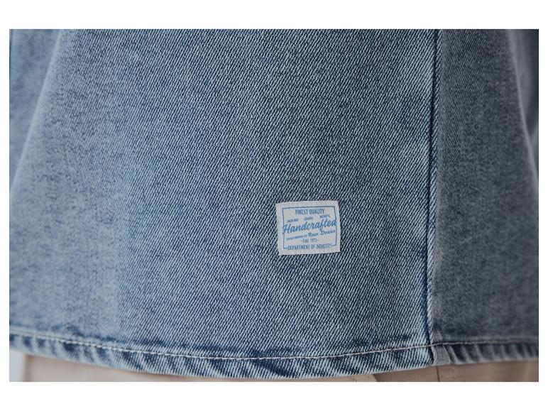 Gros plan sur un tissu en jean avec une étiquette indiquant 'Handcrafted Raw Denim'.