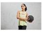 Une femme en tenue de sport tient un ballon de médecine.