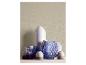 Une collection de vases de différentes formes et couleurs, y compris du verre bleu et de la céramique blanche.