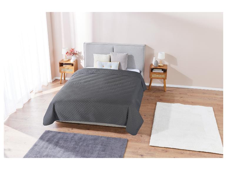 Couette matelassée grise et tapis moelleux dans une chambre moderne.