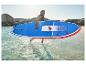 Homme souriant portant un paddleboard bleu et rouge dans l'eau.