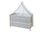 Un lit bébé avec un ciel de lit en tissu blanc