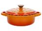 Cocotte orange en fonte avec couvercle.