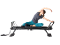 Femme pratiquant le pilates sur un reformer de pilates noir.