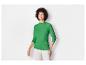 Une femme porte un haut vert à manches longues.