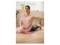 Une femme faisant du yoga avec un ballon d'exercice rose sur un tapis.