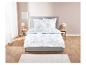 Parure de lit fleurie et couette sur lit gris.
