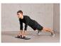 Un homme fait des pompes avec des barres de pompes sur un tapis de sport.