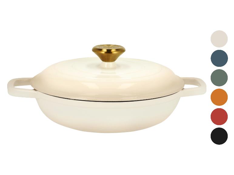 Cocotte en fonte couleur crème avec un bouton doré et des échantillons de couleurs