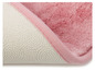 Tapis de bain rose avec une base antidérapante.