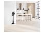 Aspirateur balai et accessoires accrochés au mur dans une cuisine moderne.