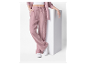 Femme portant un pantalon ample rose et des baskets blanches.
