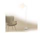 Lampadaire blanc éclairant un fauteuil beige dans un intérieur minimaliste.