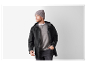 Homme en bonnet gris et veste noire.