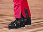 Des chaussures de ski noires avec un pantalon de ski rouge
